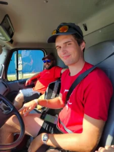 two movers at country club moving in the front seat of a moving truck